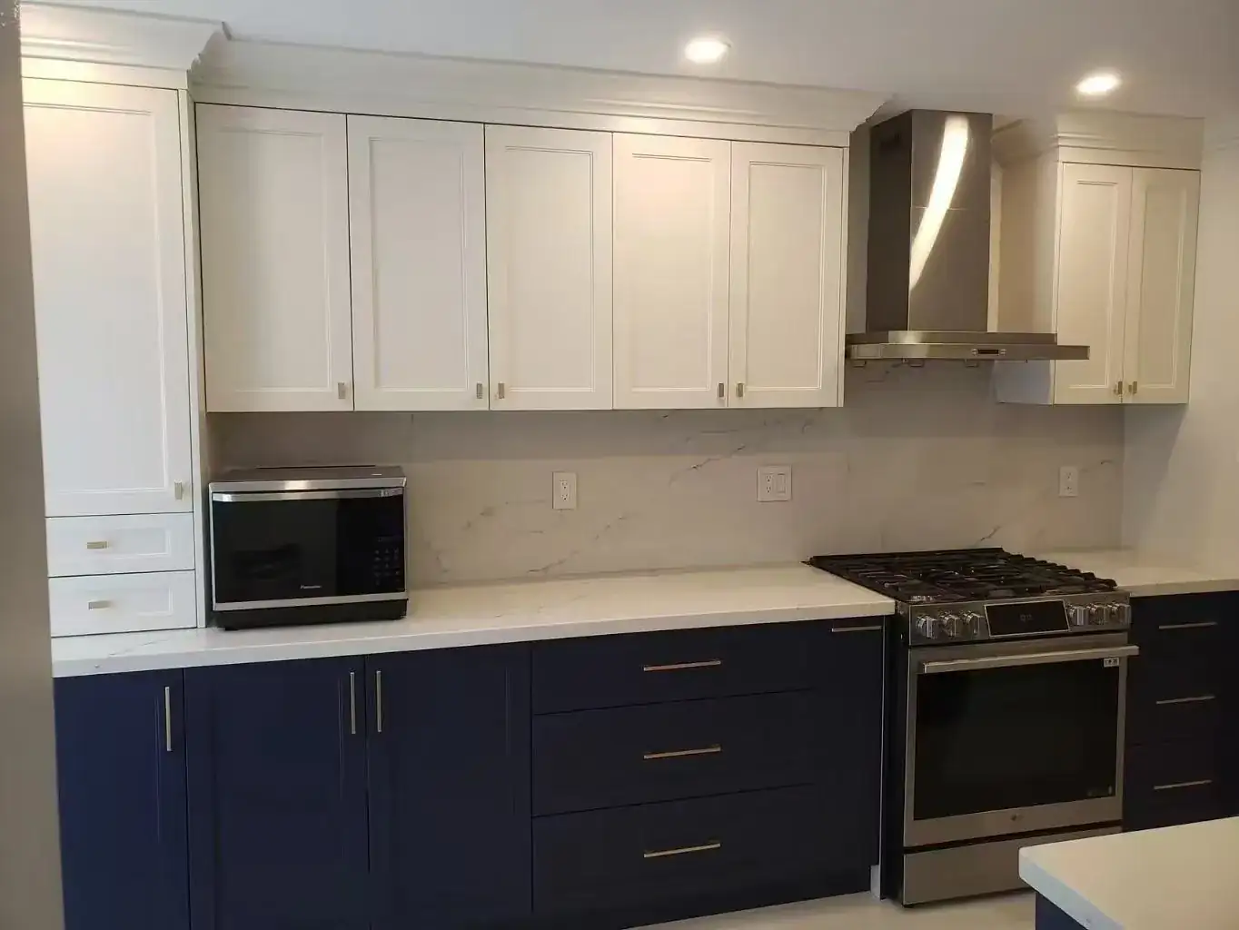 Kitchen with white shaker upper cabinets and navy shaker lower cabinets